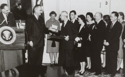 Black and white photo of an award ceremony with group of people