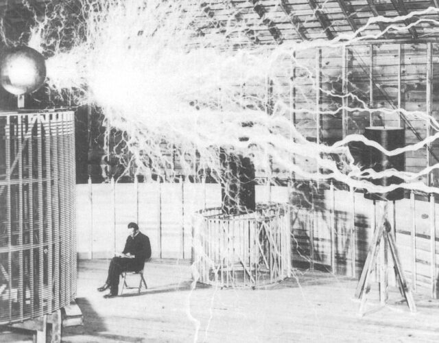 Nikola Tesla sitting under a machine shooting lightening
